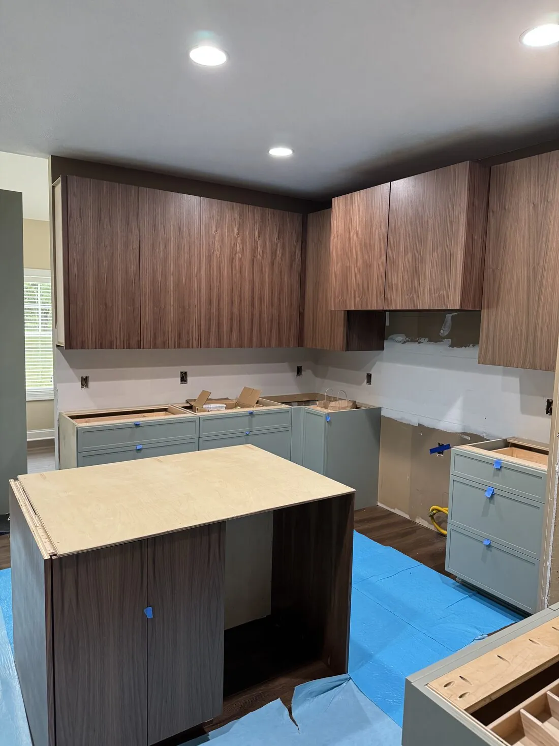 Flat-panel walnut upper cabinetry installed along the run